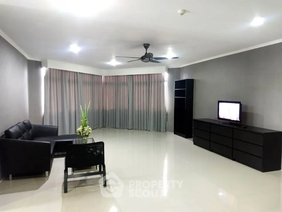 Spacious modern living room with sleek furniture and large windows.