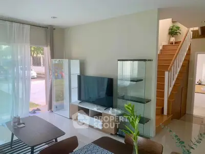 Modern living room with sleek furniture and large windows offering natural light.