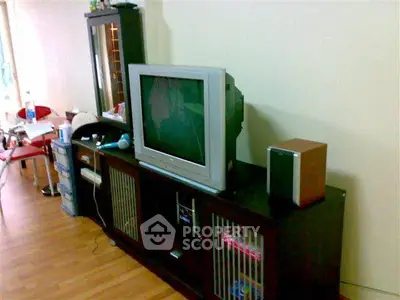 Cozy living room with vintage TV and wooden cabinet, perfect for relaxation.