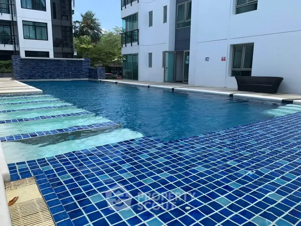 Luxurious apartment complex with a stunning outdoor pool and modern design.