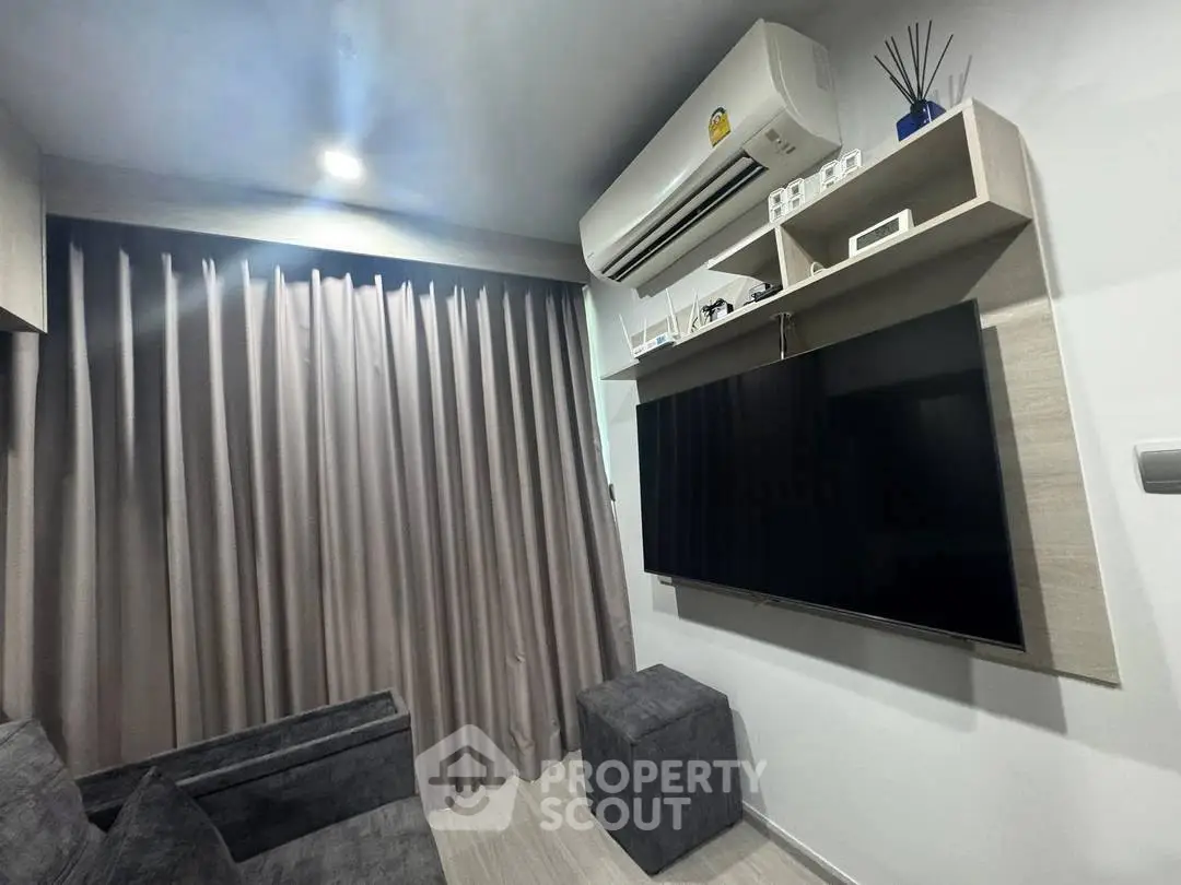 Modern living room with sleek design, featuring a wall-mounted TV and air conditioning unit.