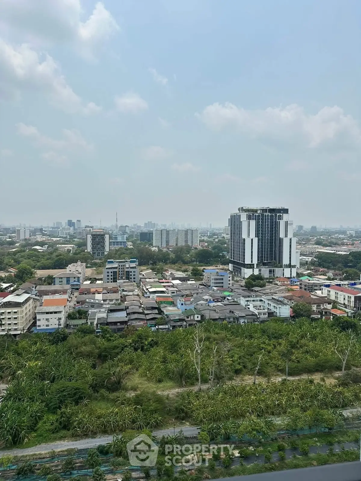 Stunning cityscape view from a high-rise building showcasing urban and green landscapes.