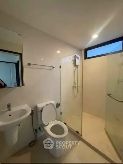 Modern bathroom with glass shower enclosure and sleek fixtures