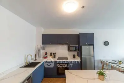 Modern kitchen with sleek navy cabinets and marble countertops