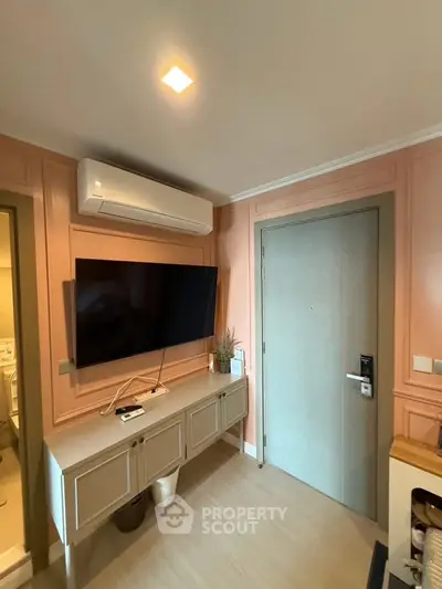 Modern living room with wall-mounted TV and air conditioning in stylish apartment.