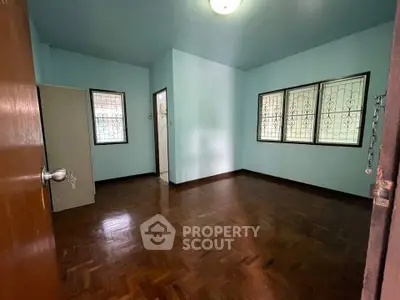 Spacious empty bedroom with wooden flooring and natural light