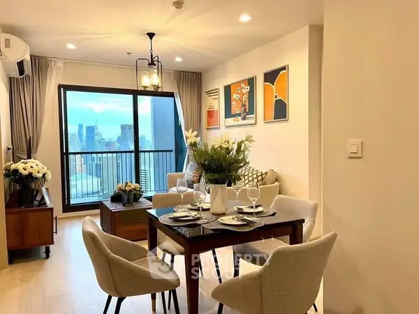 Modern living room with city view, elegant decor, and dining area in a high-rise apartment.