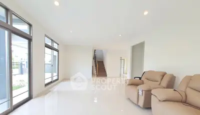 Spacious modern living room with large windows and elegant seating, perfect for family gatherings.