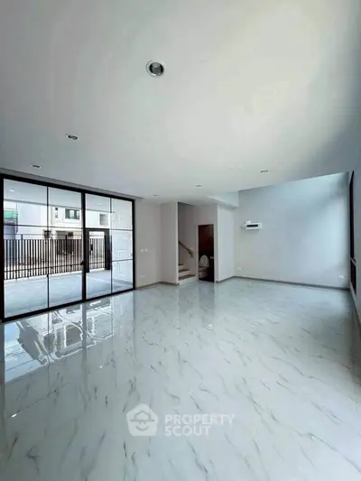 Spacious modern living room with marble flooring and large windows