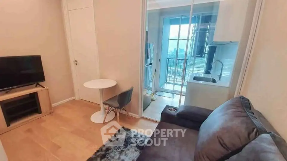 Cozy living room with modern kitchen and balcony view in a stylish apartment.