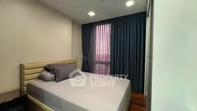 Cozy bedroom with modern decor and large window with curtains, perfect for relaxation.