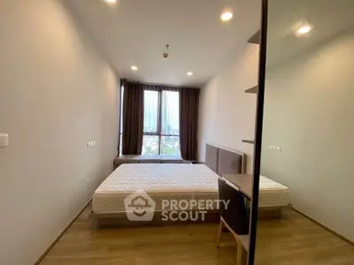 Modern bedroom with large window and minimalist design in high-rise apartment.