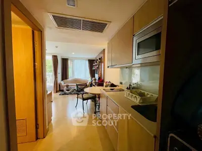 Modern open-layout kitchen with sleek cabinetry and cozy living area view.