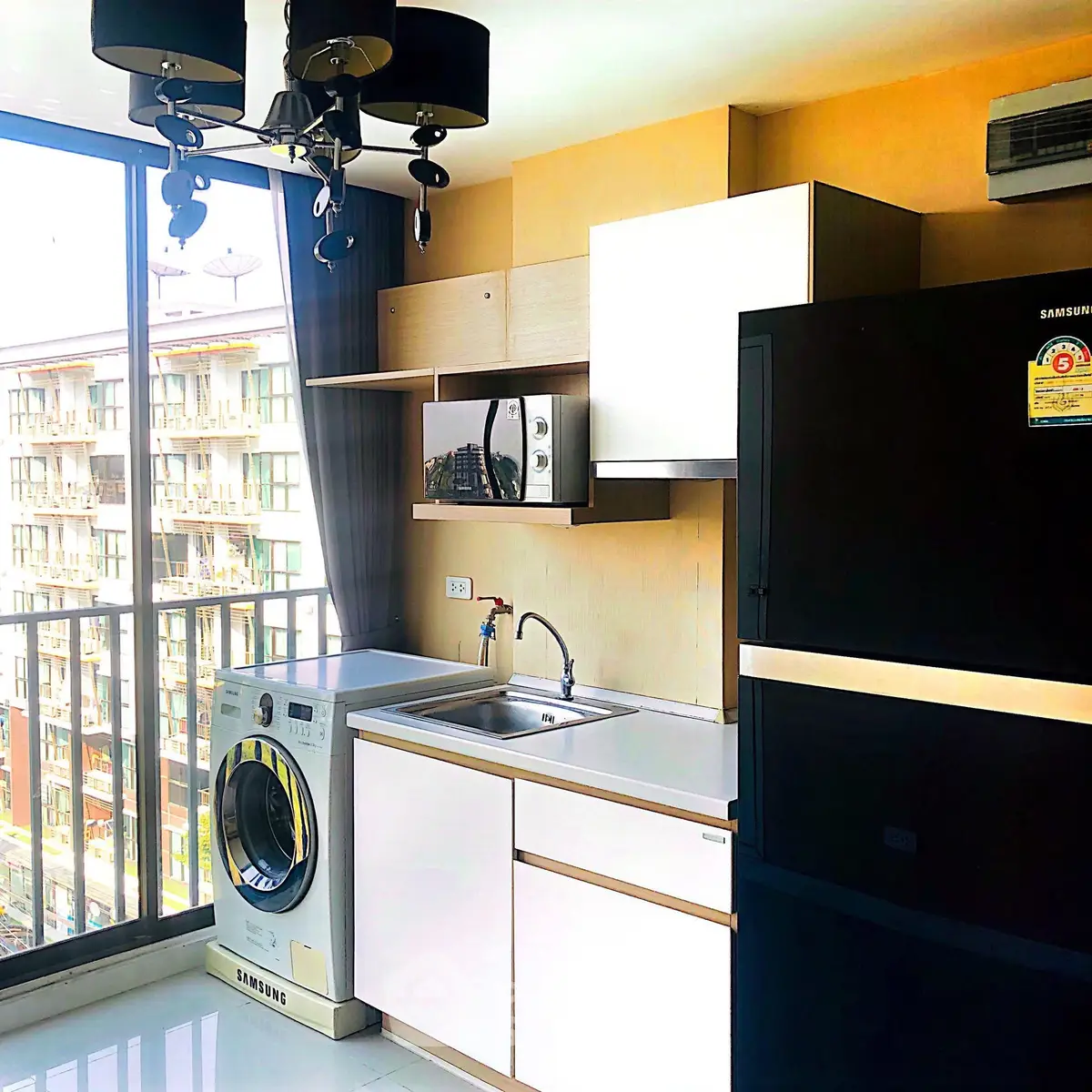 Modern kitchen with washing machine and balcony view in urban apartment