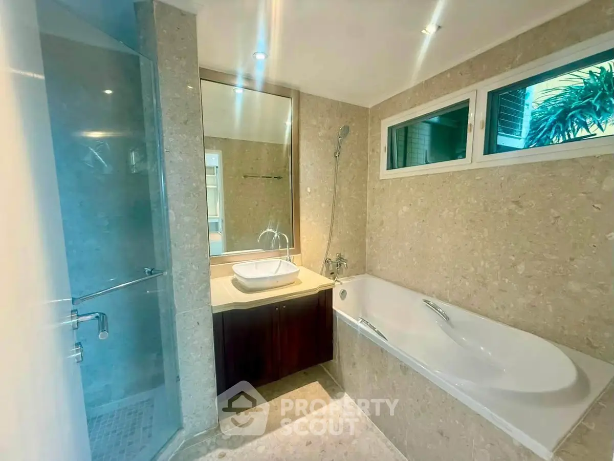 Luxurious bathroom with elegant bathtub and modern shower in a stylish real estate property.