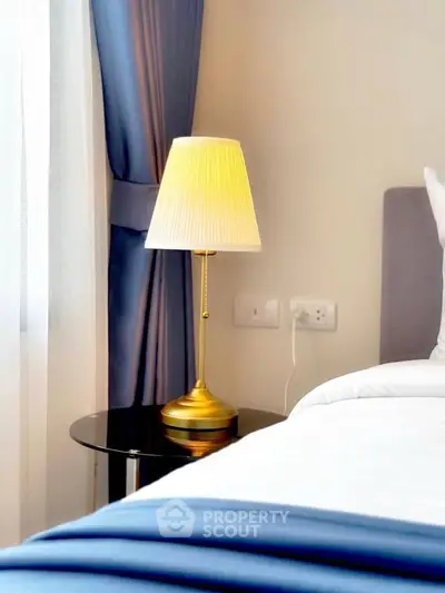Elegant bedroom corner with stylish lamp and luxurious bedding