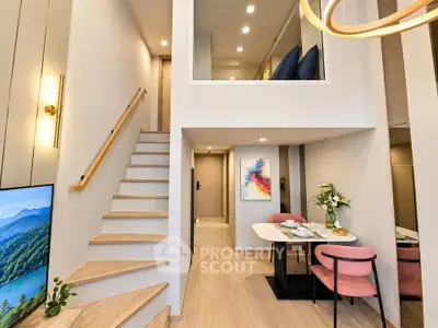 Modern duplex apartment with stylish interior, featuring a cozy dining area and elegant staircase leading to upper level.