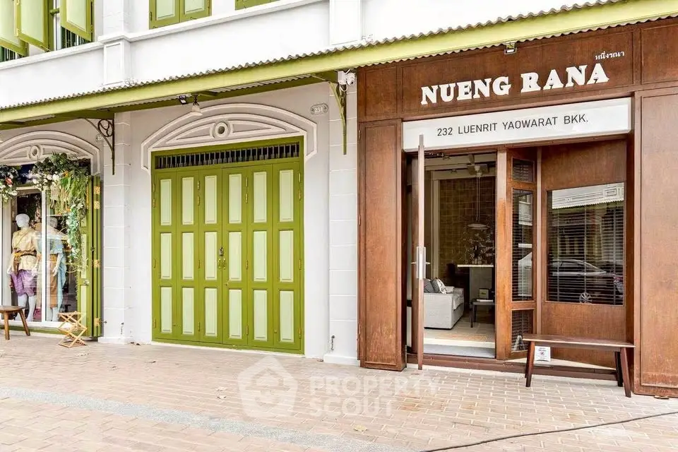 Charming storefront with green doors and inviting entrance in Bangkok's Yaowarat area.