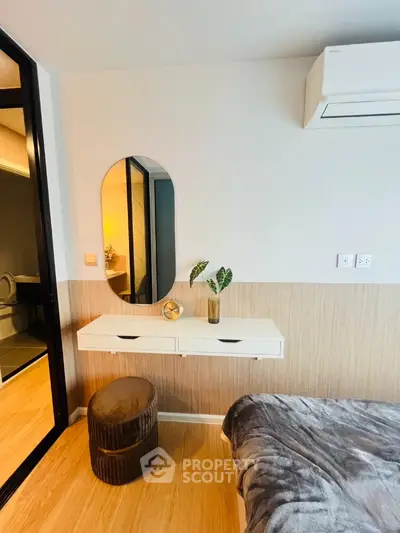 Modern bedroom with stylish decor and air conditioning unit, featuring a cozy bed and elegant vanity.