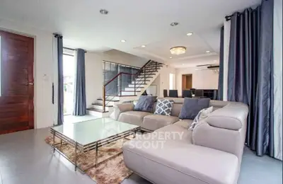 Spacious modern living room with elegant staircase and plush seating