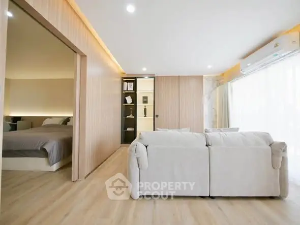 Spacious modern living room with open layout and cozy bedroom view