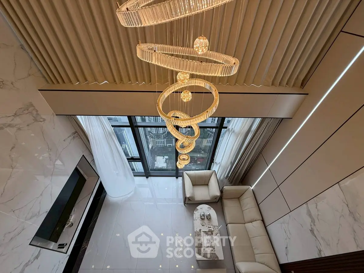 Luxurious high-ceiling living room with elegant chandelier and panoramic city view.