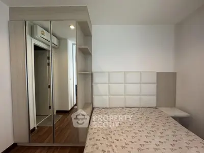 Modern bedroom with mirrored wardrobe and stylish headboard