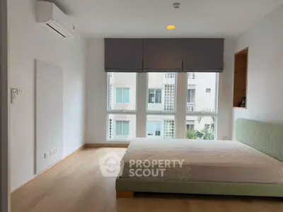 Spacious bedroom with large windows and modern air conditioning unit