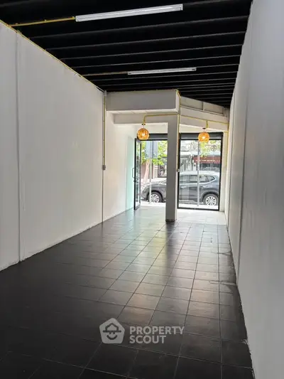 Spacious commercial space with modern lighting and large glass entrance, ideal for retail or office use.