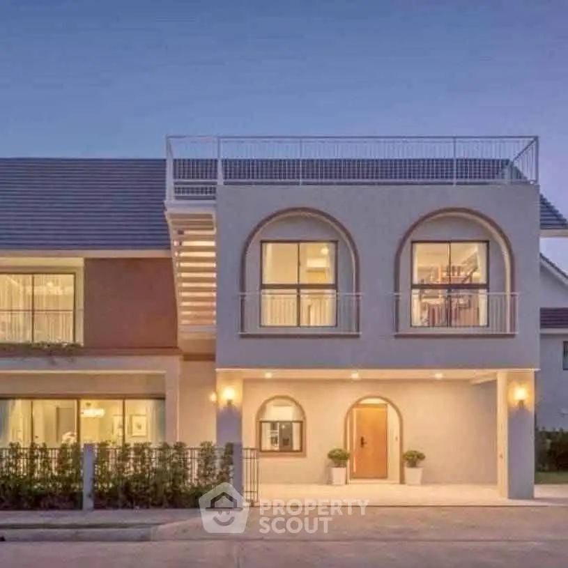 Stunning modern two-story house with large windows and elegant facade at dusk.