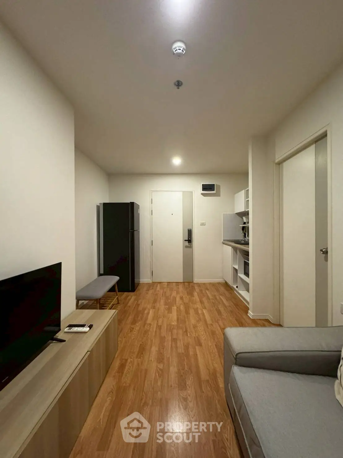 Modern living room with wooden flooring and sleek furniture in a cozy apartment.