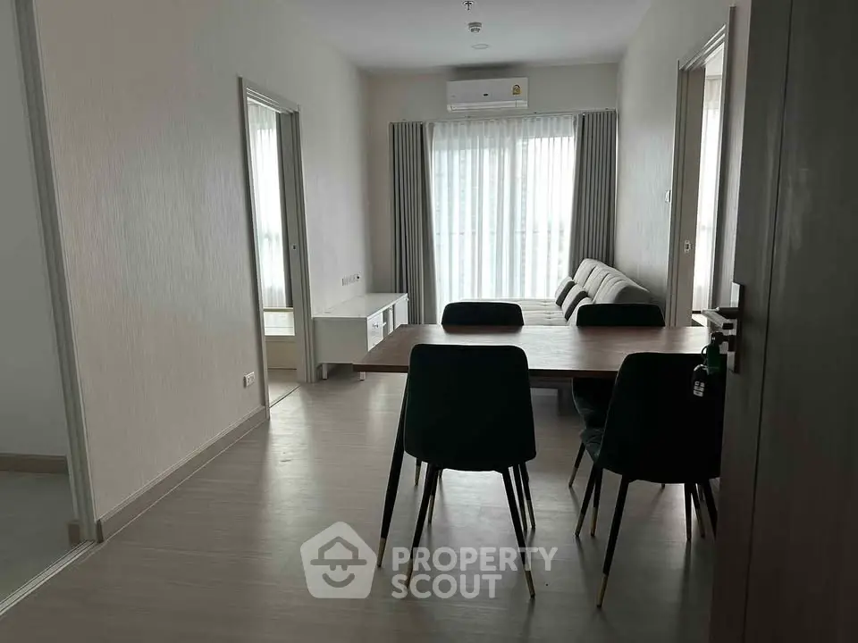 Modern dining area with sleek table and chairs, bright natural light, and minimalist decor.