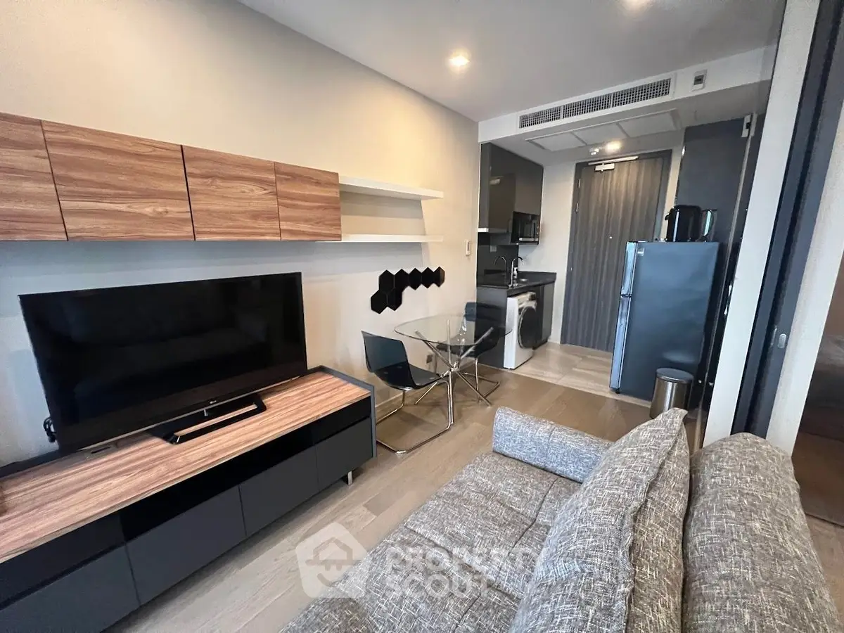 Modern living room with sleek furniture and open kitchen layout in a stylish apartment.