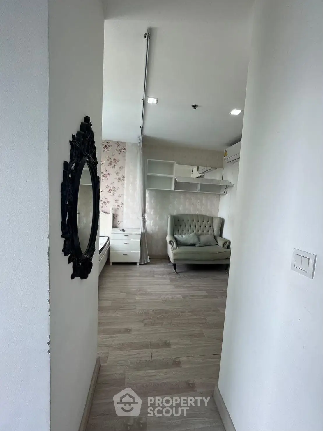 Charming entryway leading to a cozy living area with elegant decor and floral wallpaper.