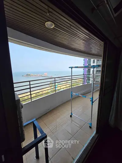 Stunning balcony with panoramic sea view in modern high-rise apartment.
