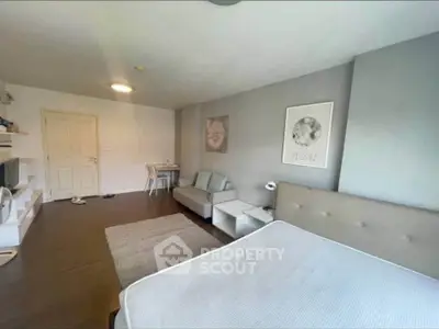 Spacious modern bedroom with cozy seating area and stylish decor