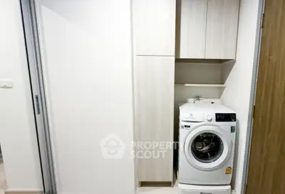 Modern laundry area with washing machine and sleek storage cabinets