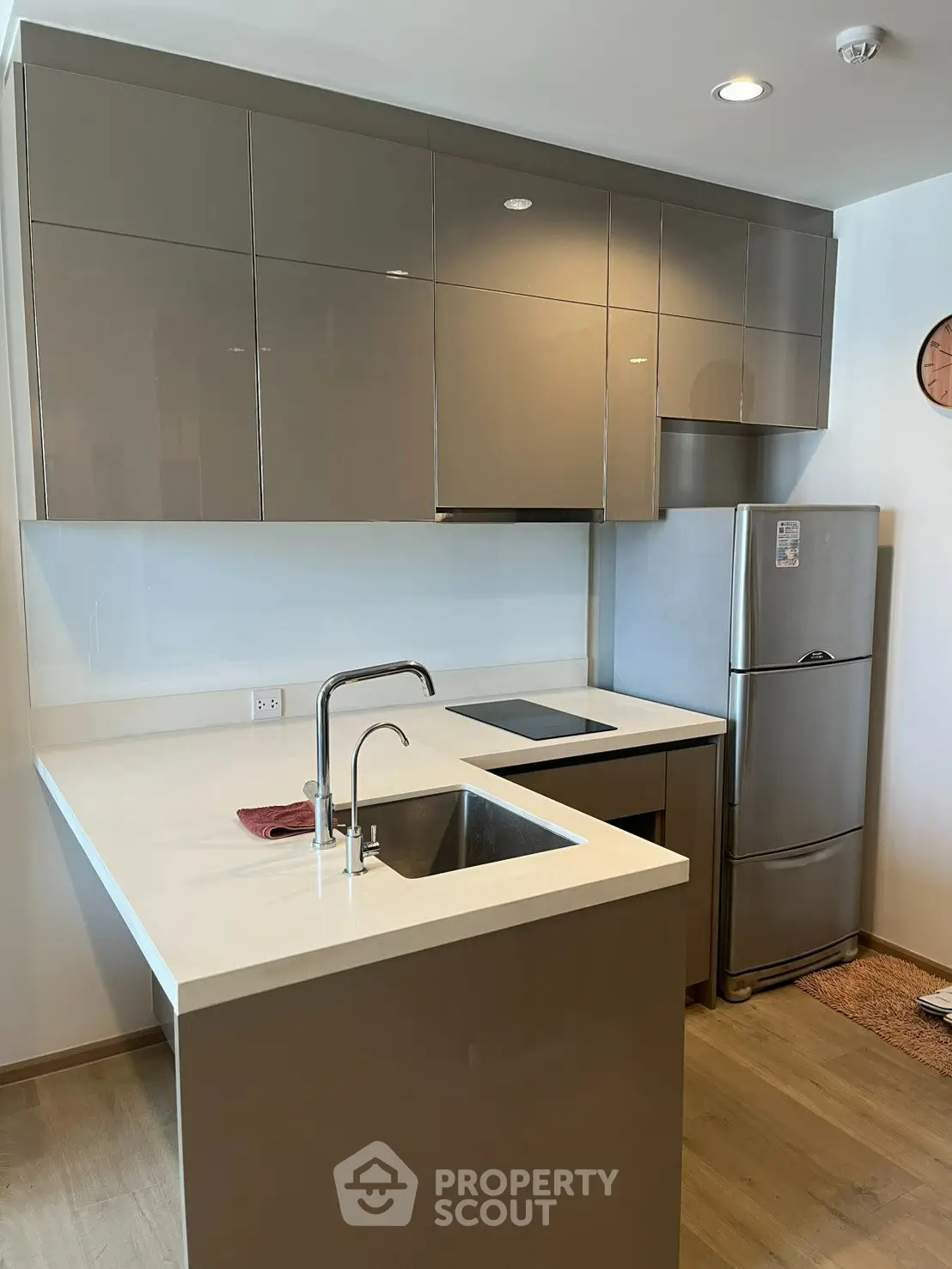 Modern kitchen with sleek cabinetry and stainless steel appliances in a stylish apartment.