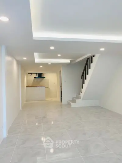 Spacious modern living room with sleek staircase and open kitchen layout