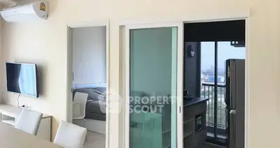 Modern apartment interior with sliding glass doors and city view balcony.