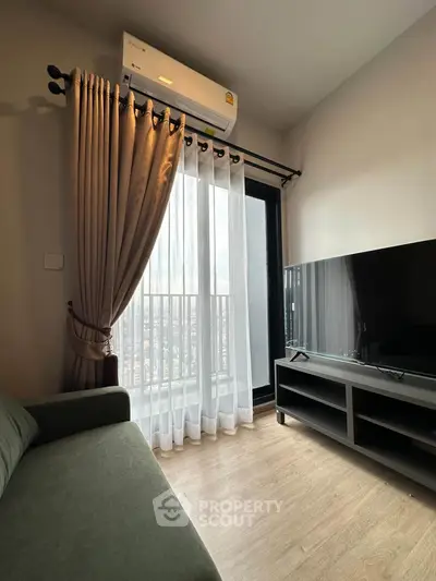 Modern living room with large window, air conditioning, and sleek TV setup.