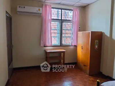 Cozy bedroom with air conditioning and wooden furniture, perfect for comfortable living.