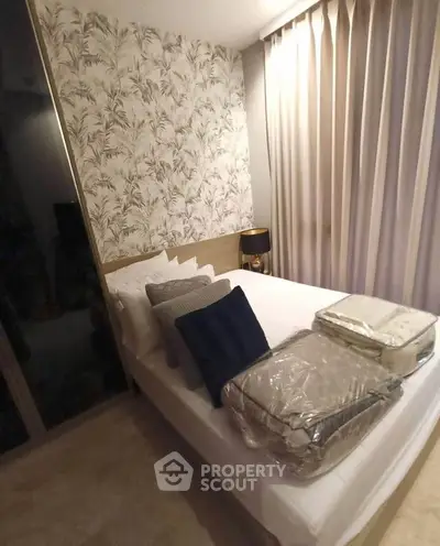 Cozy bedroom with elegant wallpaper and soft lighting, perfect for relaxation.