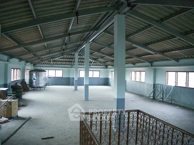 Spacious industrial loft with high ceilings and ample natural light, ideal for creative workspace or storage.