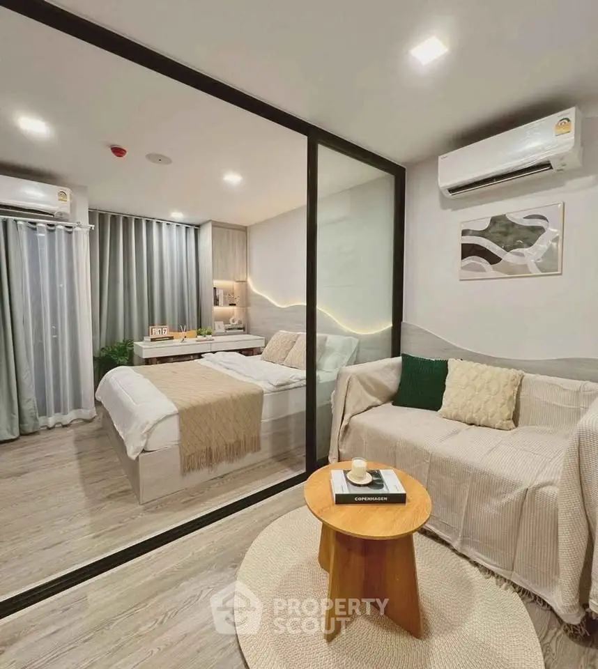 Modern studio apartment with glass partition, cozy living area, and stylish bedroom.
