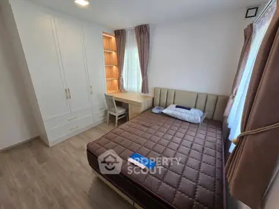 Cozy bedroom with modern furnishings, featuring a comfortable bed, built-in wardrobe, and a study desk by the window.