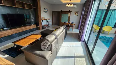 Luxurious living room with pool view, modern furniture, and abundant natural light in a stylish home.