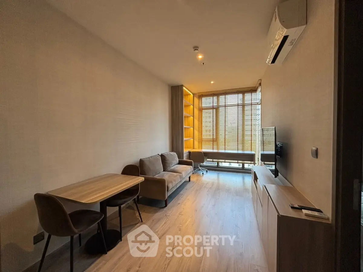Modern living room with cozy sofa, dining table, and large window for natural light.