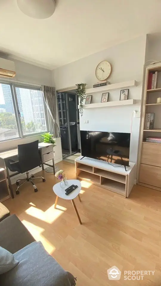 Sunlit cozy living room with modern furnishings, ample shelving, and a comfortable workspace, perfect for relaxation and productivity.