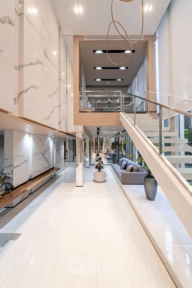 Luxurious modern living room with high ceilings and elegant staircase